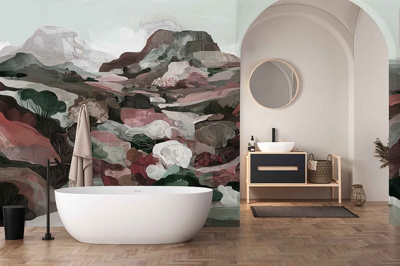 Abstract landscape mural wallpaper features soft, overlapping mountain shapes in hues of terracotta, blush pink, sage green, and deep teal. Stylized foliage in mustard yellow and olive green adds depth. The design sits under elegant arches, creating a contemporary yet artistic statement.