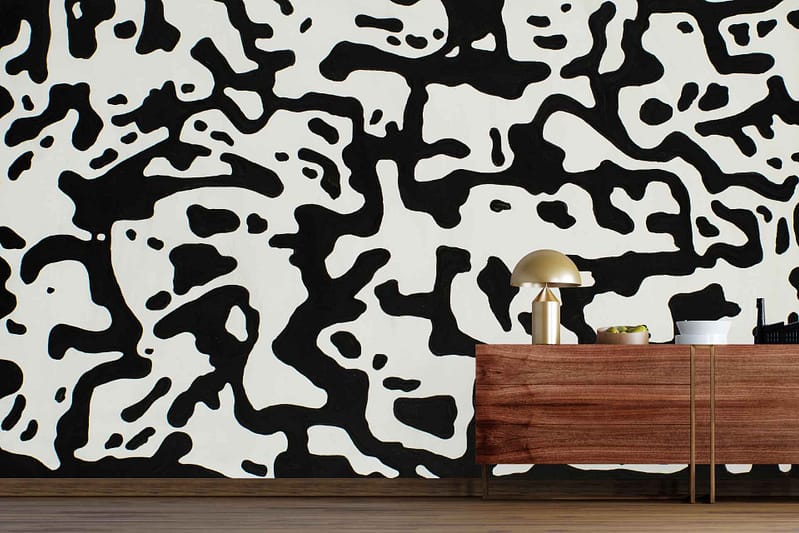 Abstract black and white wallpaper with irregular cow spot shapes, resembling Ebony Root pattern. Bold contrast of black and white creates a striking, organic look perfect for modern or statement walls.