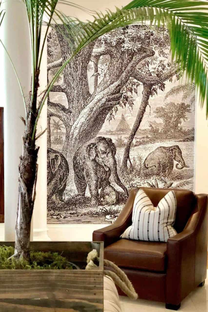 The wallpaper features a serene natural landscape with elephants, showcasing earthy browns, soft greens, and muted blues. The elephants are detailed against a backdrop of lush foliage and expansive skies, creating an artistic blend of nature-inspired hues.