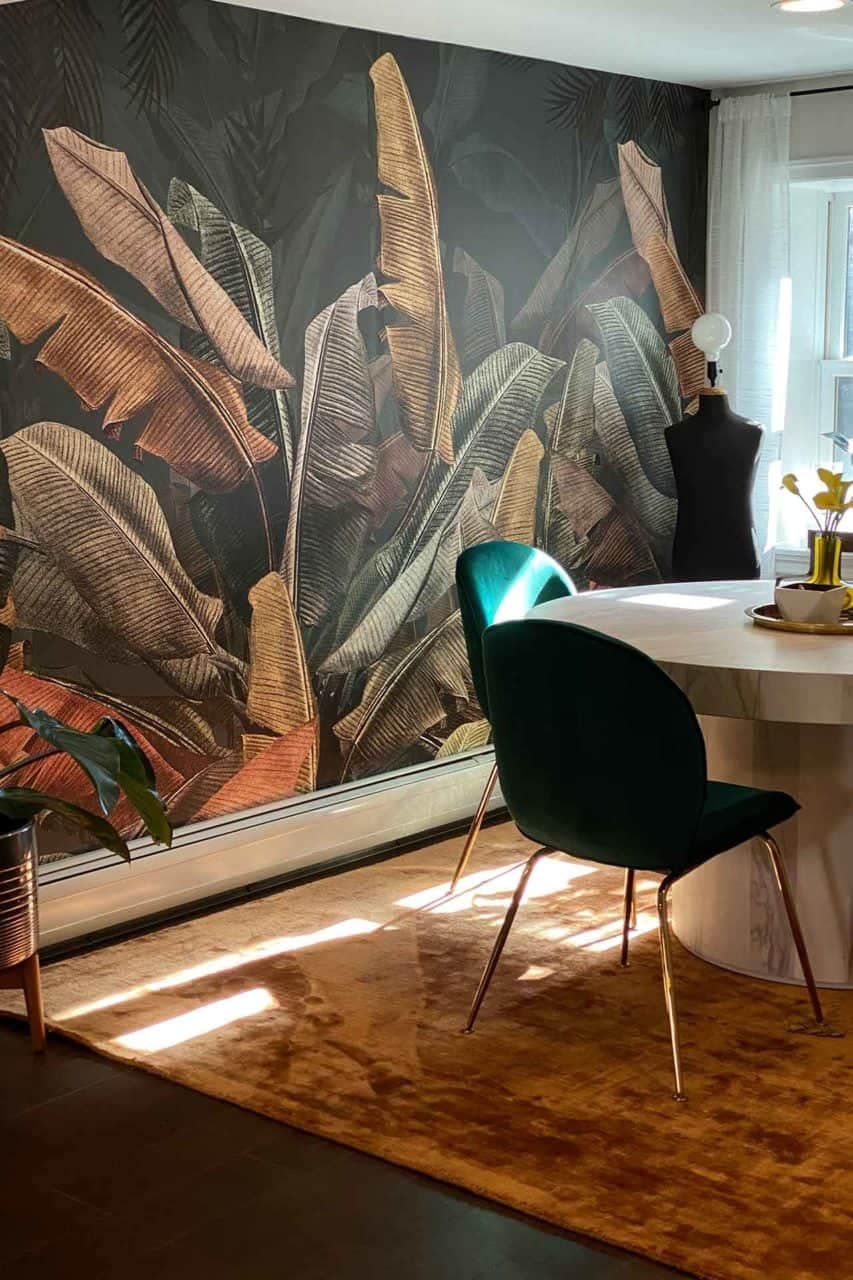 Dark walls adorned with a large, tropical leaf mural featuring lush green leaves.