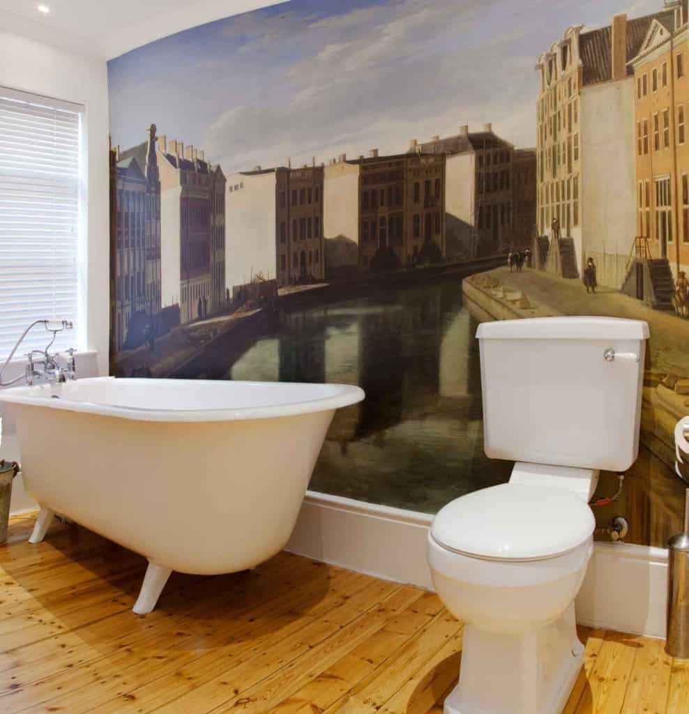 Large mural depicting an old European canal with nostalgic buildings. Features classic architecture, cobblestone paths, and serene waterway. Predominantly earth tones—browns, beiges, and grays—enhanced by muted blues and greens. Hints of historical elements and artistic ambiance throughout.