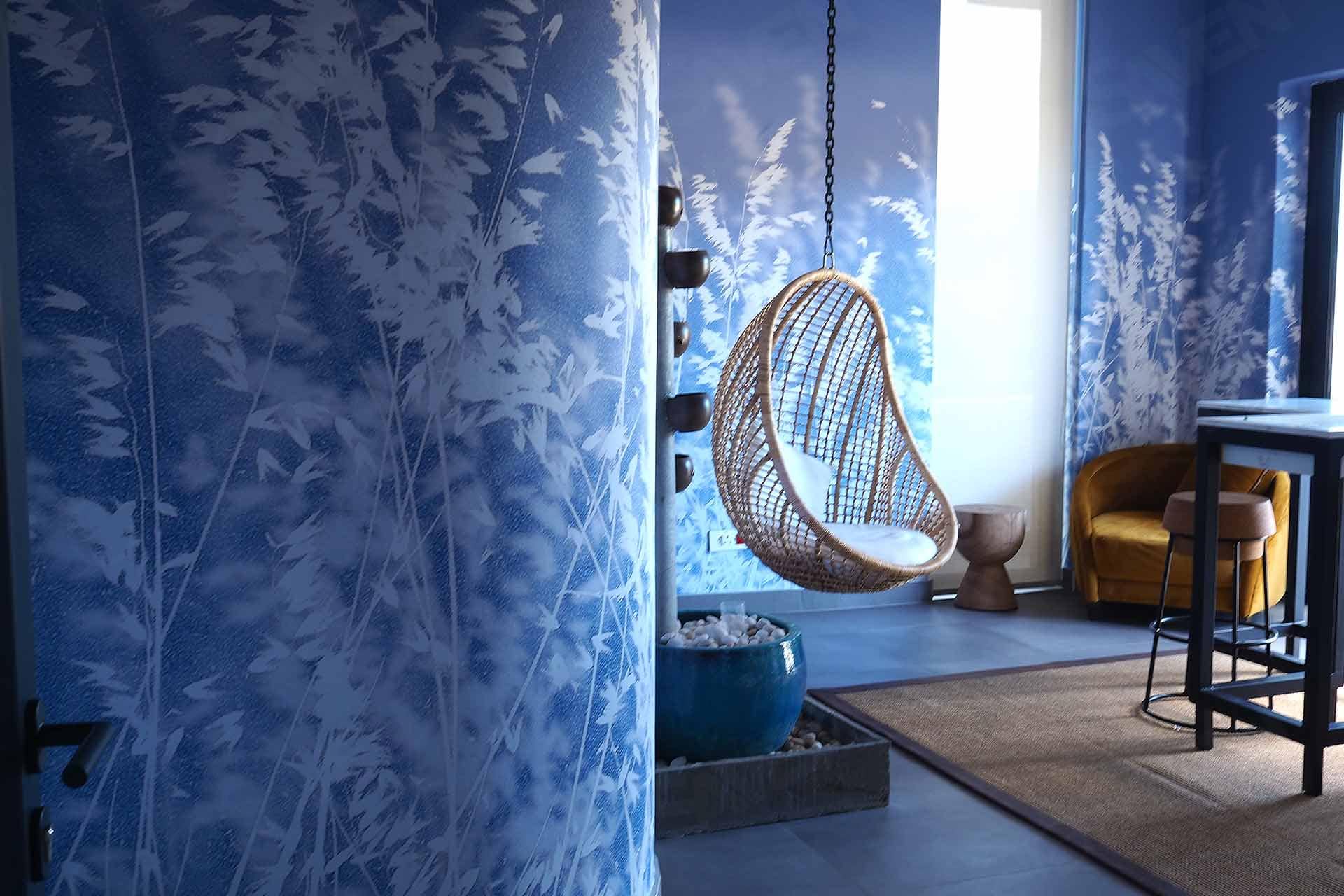 Nature-themed wallpaper, blue painted walls, white foliage silhouettes