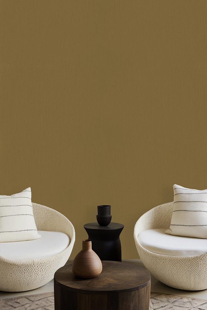 Olive-green wallpaper. White chairs with striped cushions. Small dark coffee table. Black, brown, and terracotta vases. Larger wooden table in the foreground. Minimalist living room design elements highlighted for search: olive-green wallpaper with complementary furnishings and decor colors (white, black, brown, terracotta).