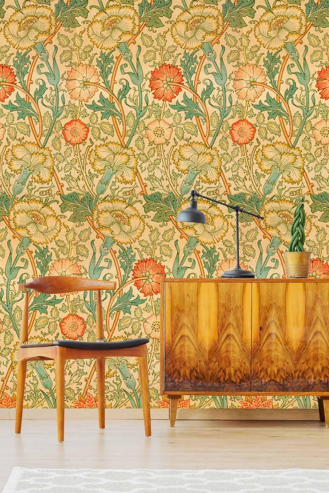 The wallpaper features vibrant, vintage-style floral patterns with bold blooms in shades of orange, red, and yellow. Green leafy accents provide contrast against a soft cream background. Intricate detailing adds to the mid-century charm, evoking the cozy essence of a Swiss Cottage.