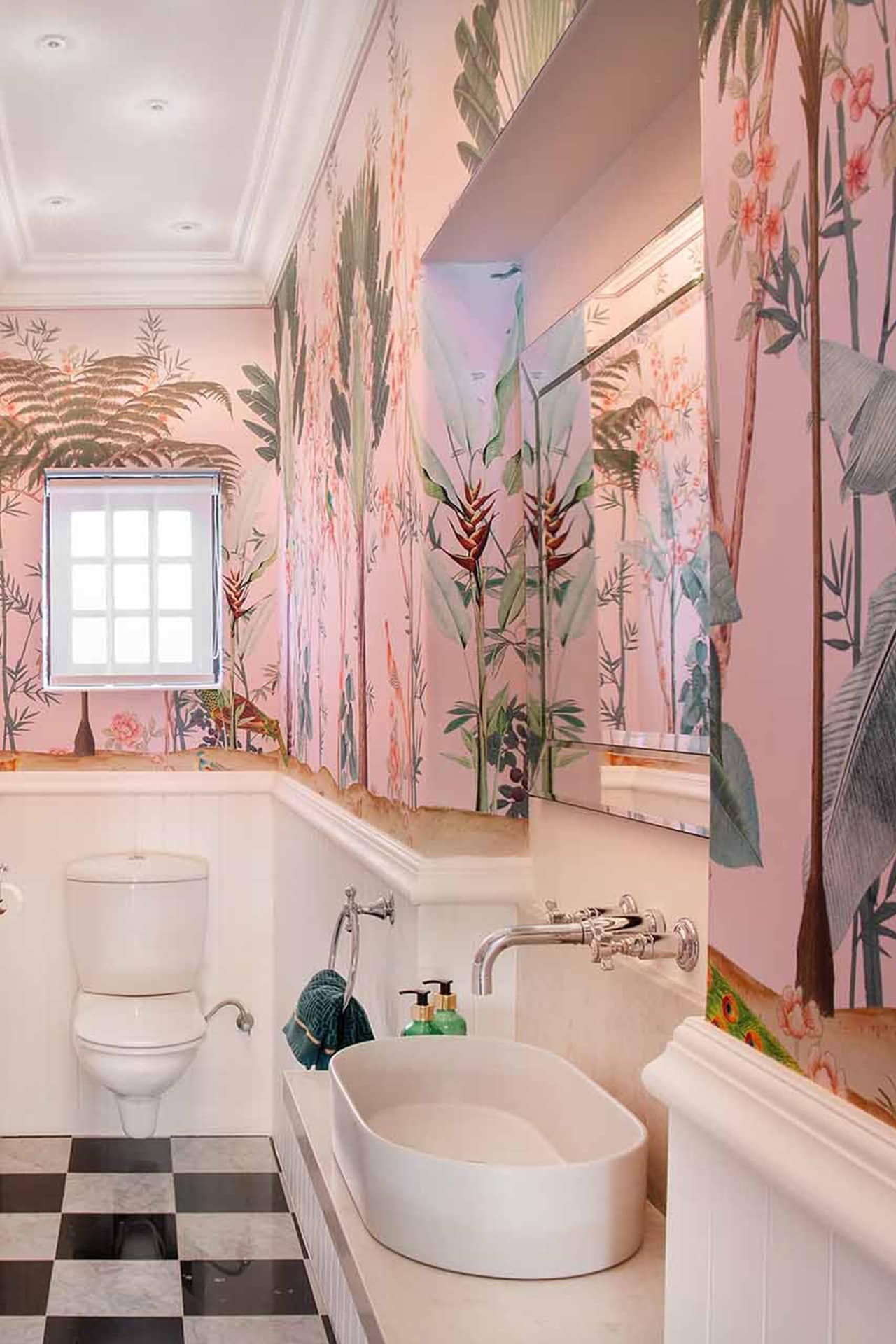 The wallpaper showcases vibrant tropical elements with lush green palm trees and dense foliage, accented by hints of yellow, deep blues, and occasional bursts of red flowers.