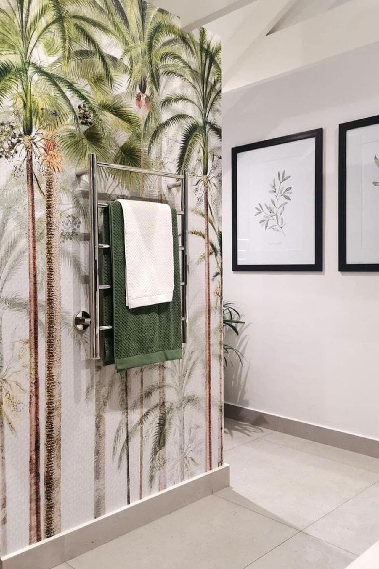 The bathroom features a striking tropical palm tree mural that acts like wallpaper. The mural showcases lush green palm fronds and tall tree trunks against a vibrant, breezy background. Hints of blue sky and earthy tones add to the tropical ambiance, creating a vivid, inviting look.
