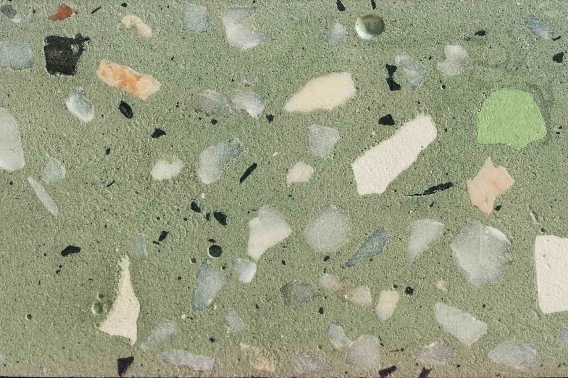 A close-up wallpaper of a terrazzo surface with a green cement matrix, featuring variously sized and colored stone and marble chips. Shades of white, black, gray, and peach create a speckled, mosaic-like pattern. Ideal for a vintage art aesthetic.

**Elements & Colors:**
- Green cement matrix
- Stone & marble chips
- Various sizes
- Colors: White, Black, Gray, Peach
- Speckled pattern
- Mosaic-like design