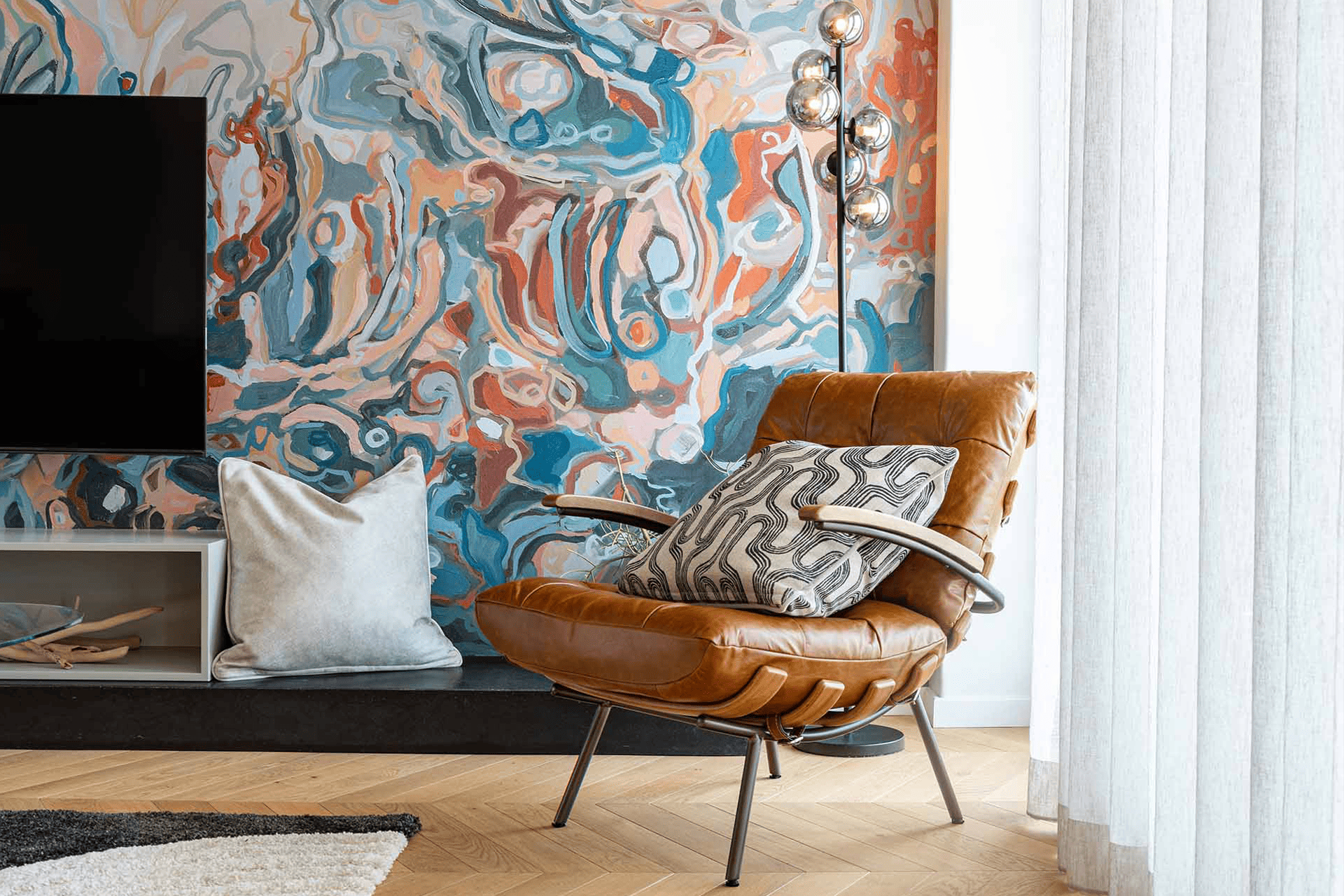 Vibrant living room wallpaper features bold, colorful patterns with rich hues and intricate designs, creating a lively backdrop behind the furniture.