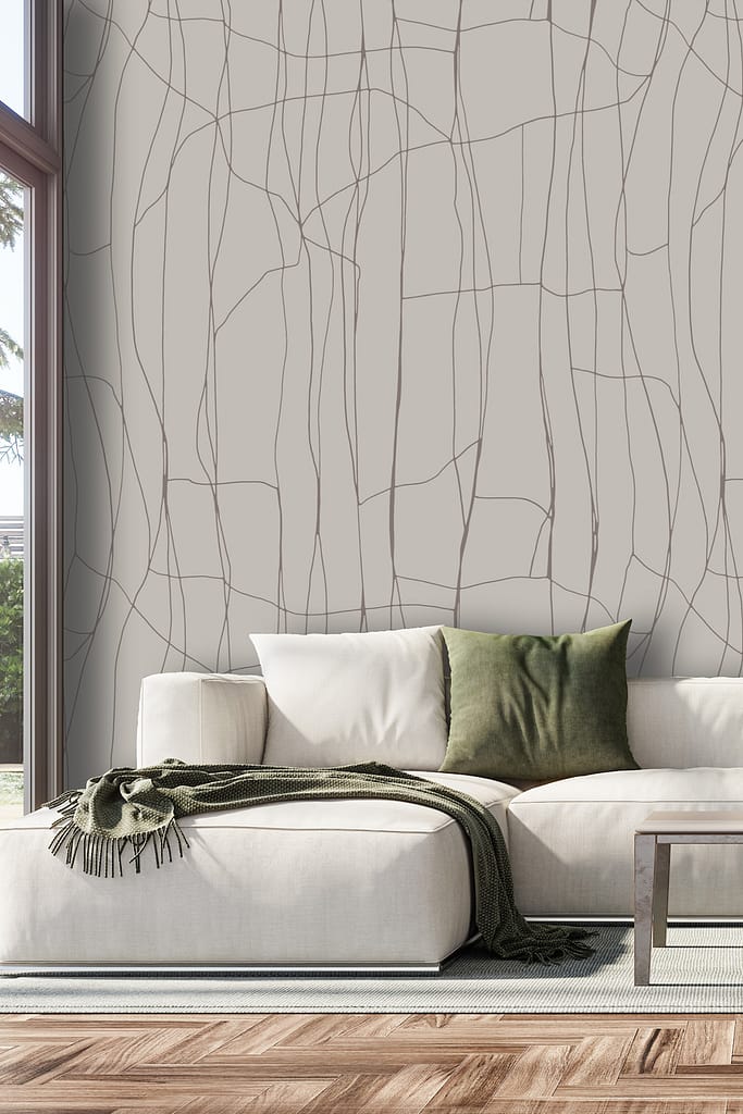 The wallpaper features an abstract vertical line pattern inspired by saree designs, with lines in varying shades of green, gold, and subtle white against a soft off-white background. The design incorporates slender metallic accents and delicate textures, evoking traditional woven textiles but with a modern, minimalist touch.
