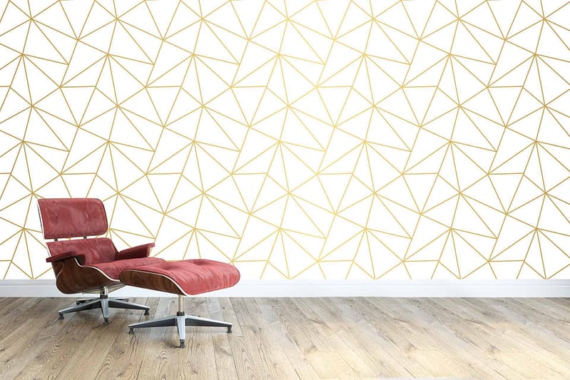 The wallpaper features a white background with a gold geometric pattern. The design includes symmetrical shapes and clean lines that create a modern yet elegant look. The use of metallic gold against the pure white adds a touch of luxury and sophistication to the minimalist space.