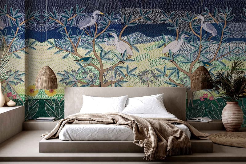The wallpaper features a vibrant mural depicting birds perched on trees. Elements include various species of birds, intricate tree branches, and leaves, all in vivid colors such as blues, greens, reds, and yellows. The lively design adds a dynamic focal point to the bedroom decor.