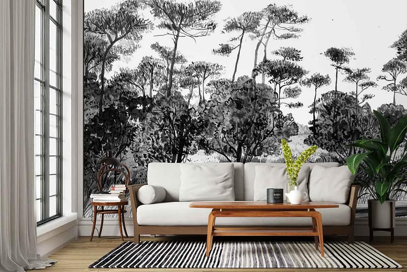 The wallpaper is a large black-and-white mural depicting tall trees, dense foliage, and detailed forest scenery. It features high-contrast grayscale shades, fine linework showing tree trunks, branches, and leafy canopies. The overall effect is a dramatic nature-inspired backdrop with intricate botanical elements.