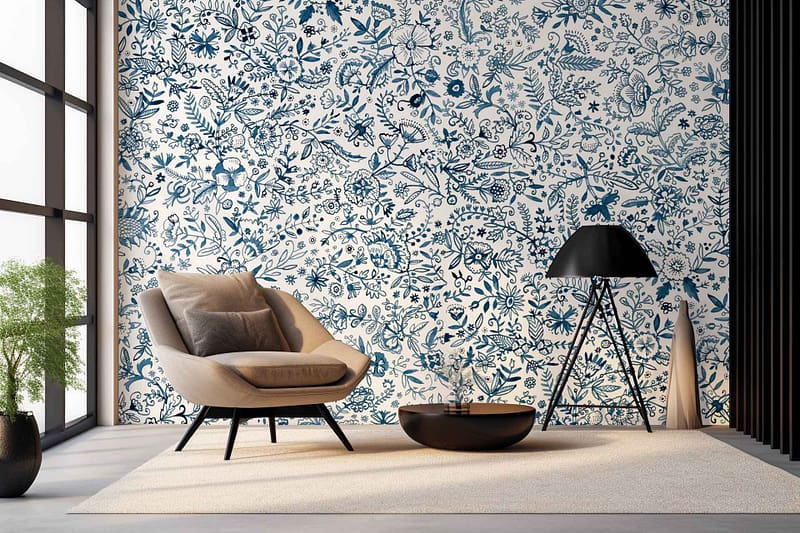 The highlight of this modern living room is an expansive, white wall adorned with the intricate floral patterns of Blue Ming wallpaper. The design features elaborate blue floral motifs intricately woven into the white background, adding a touch of elegance and sophistication to the space. The blue hues range from deep navy to soft sky blue, creating depth and contrast within each flower and vine depicted on the wallpaper. Each petal and leaf is meticulously detailed, giving a sense of movement and vitality that breathes life into the room. This exquisite combination of rich blues on pristine white provides a timeless aesthetic focal point that enhances the overall ambiance.