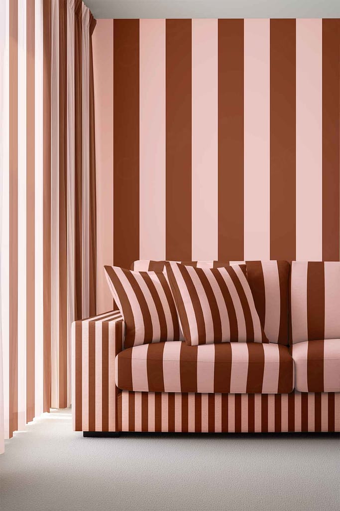 Wallpaper with bold vertical stripes in brown, pink, and copper creates a striking pattern on the wall.