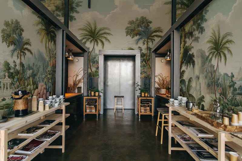 Tropical-themed wallpaper with lush greenery, palm trees, and vibrant shades of green and emerald. Tropical leaves, jungle foliage, exotic flowers in soft pastels. Earthy tones interwoven with splashes of bright colors to evoke a rich and verdant landscape. Elements of sunlit canopies and dense vegetation create a lively yet soothing atmosphere.